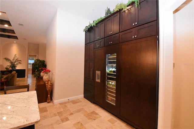 kitchen with light stone counters and dark brown cabinetry