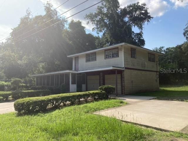 front of property featuring a sunroom and a front yard