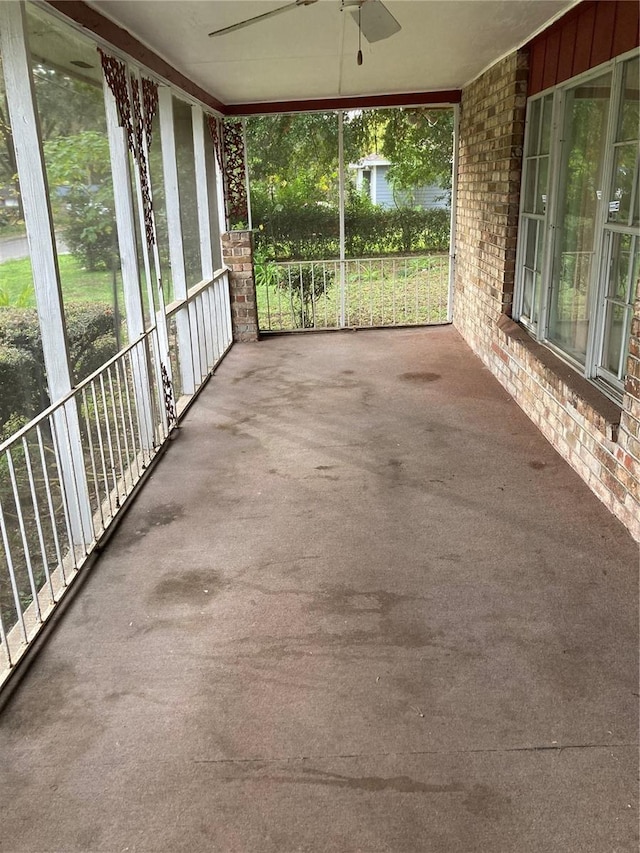 unfurnished sunroom with ceiling fan