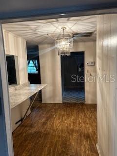 hallway with hardwood / wood-style floors and a chandelier