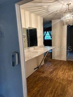 hallway with hardwood / wood-style flooring and an inviting chandelier