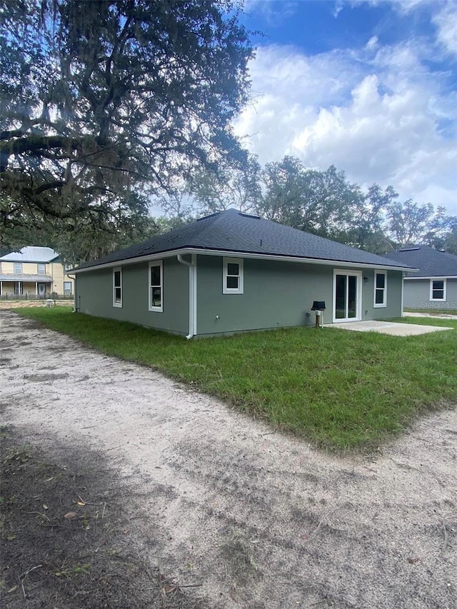 rear view of property with a patio and a lawn