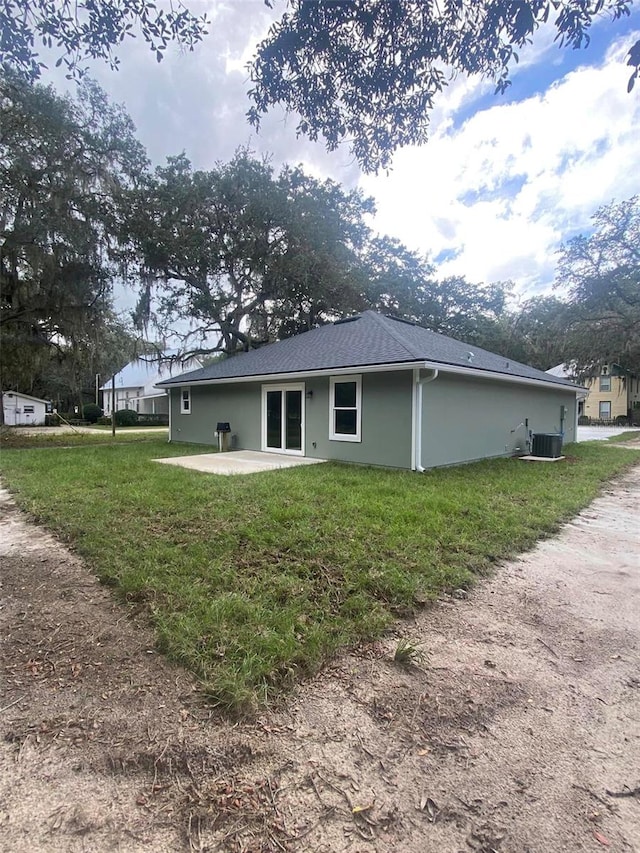 back of property featuring a yard, a patio area, and central air condition unit