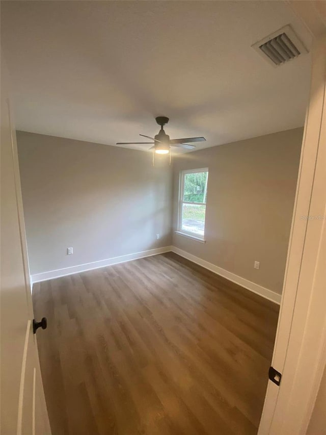 empty room featuring ceiling fan and dark hardwood / wood-style flooring