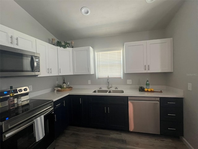 kitchen featuring sink, dark hardwood / wood-style flooring, appliances with stainless steel finishes, lofted ceiling, and white cabinets