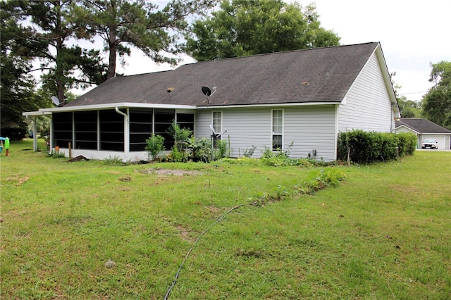 rear view of house featuring a sunroom and a lawn