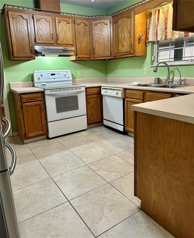 kitchen featuring sink, white appliances, and light tile patterned flooring