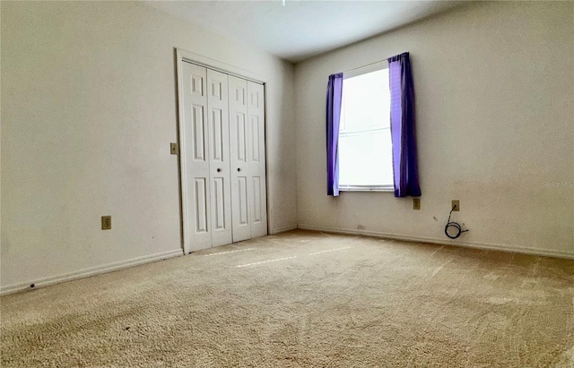 unfurnished bedroom featuring carpet flooring and a closet