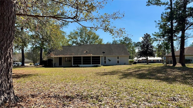 rear view of house featuring a lawn