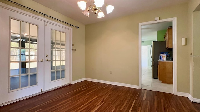 interior space with wood-type flooring, a chandelier, and french doors