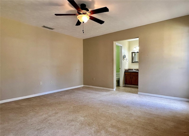 carpeted empty room with ceiling fan, sink, and a textured ceiling