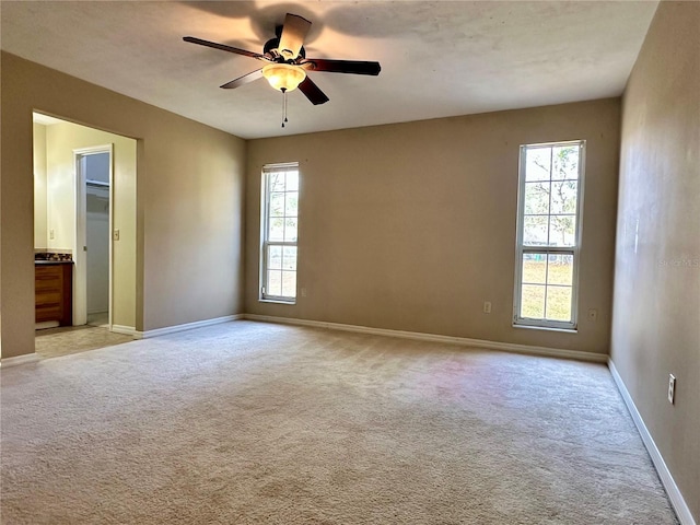 unfurnished room featuring light carpet and ceiling fan