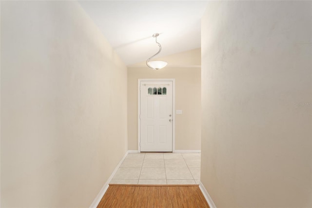 doorway featuring lofted ceiling and light wood-type flooring