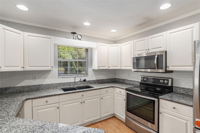 kitchen featuring crown molding, sink, white cabinetry, and stainless steel appliances