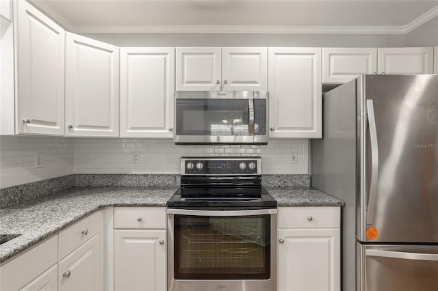 kitchen featuring white cabinets, appliances with stainless steel finishes, decorative backsplash, and ornamental molding