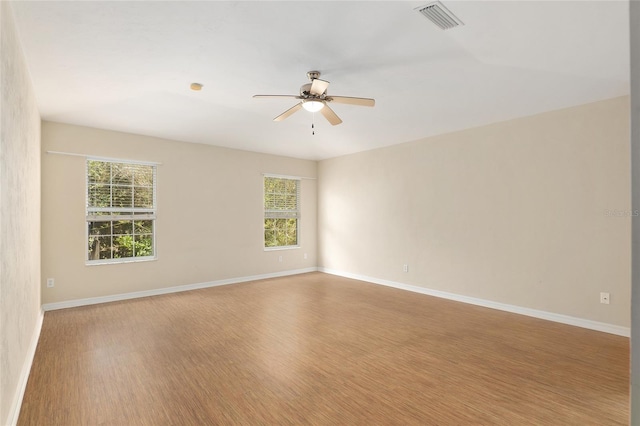 empty room with light hardwood / wood-style flooring, a wealth of natural light, and ceiling fan