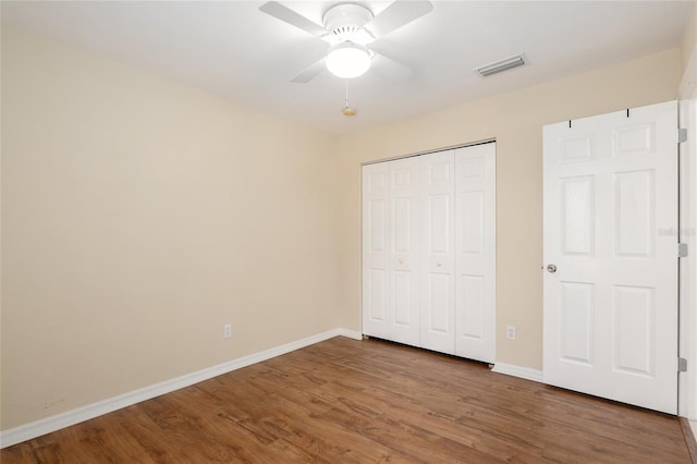 unfurnished bedroom with hardwood / wood-style flooring, ceiling fan, and a closet