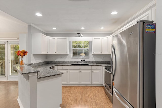 kitchen featuring kitchen peninsula, sink, white cabinets, and stainless steel appliances