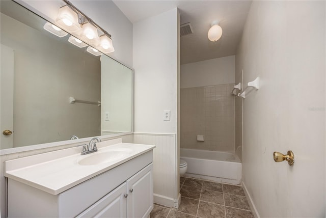 full bathroom with tiled shower / bath combo, vanity, toilet, and tile patterned flooring