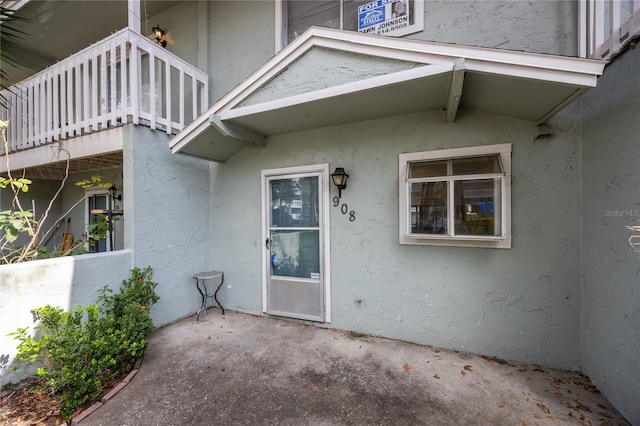 property entrance featuring a patio area and a balcony