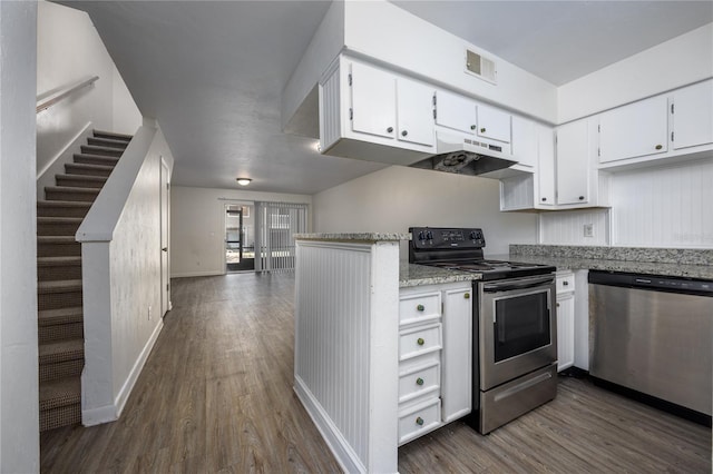 kitchen with white cabinets, appliances with stainless steel finishes, light stone counters, and dark hardwood / wood-style floors