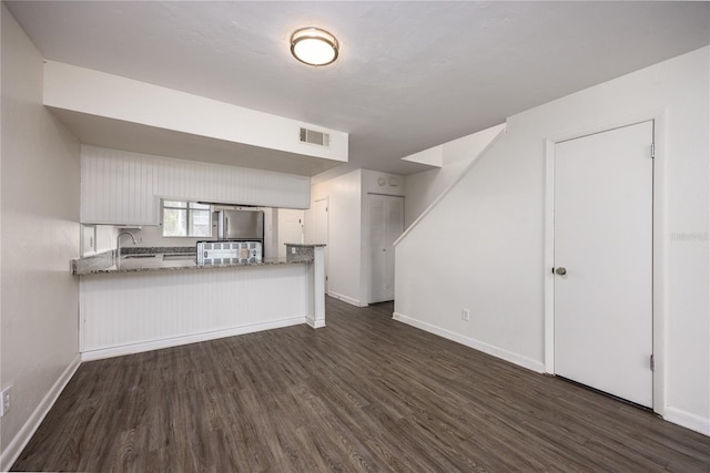 unfurnished living room with sink and dark wood-type flooring