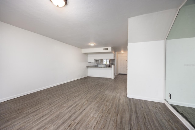 unfurnished living room featuring dark wood-type flooring