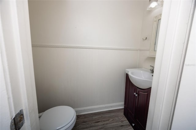 bathroom with hardwood / wood-style floors, toilet, and vanity