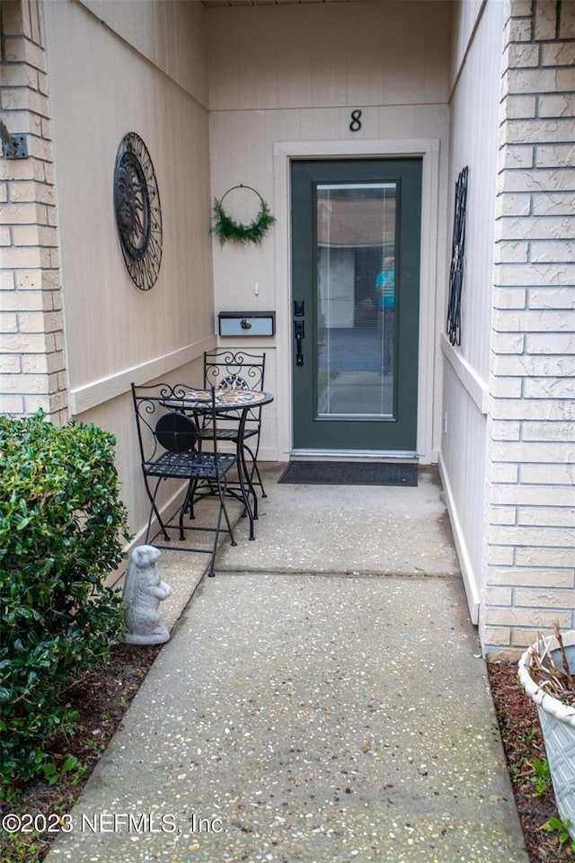 entrance to property featuring brick siding