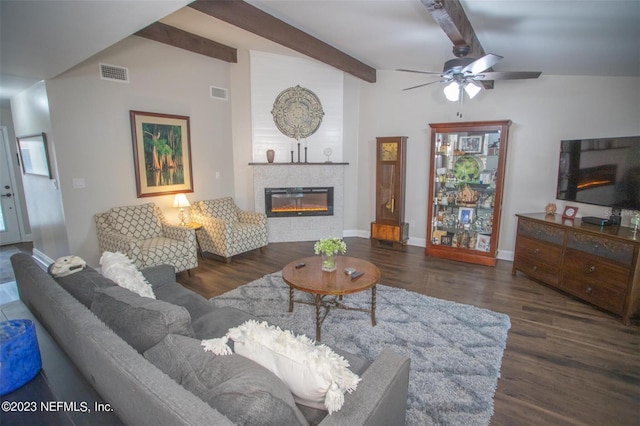 living room featuring vaulted ceiling with beams, a fireplace, ceiling fan, and dark wood-type flooring