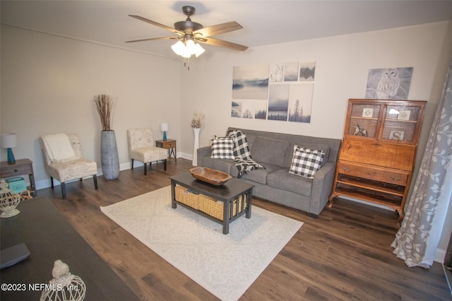 living room with dark wood-type flooring, baseboards, and a ceiling fan