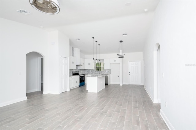 unfurnished living room featuring light hardwood / wood-style floors and a high ceiling