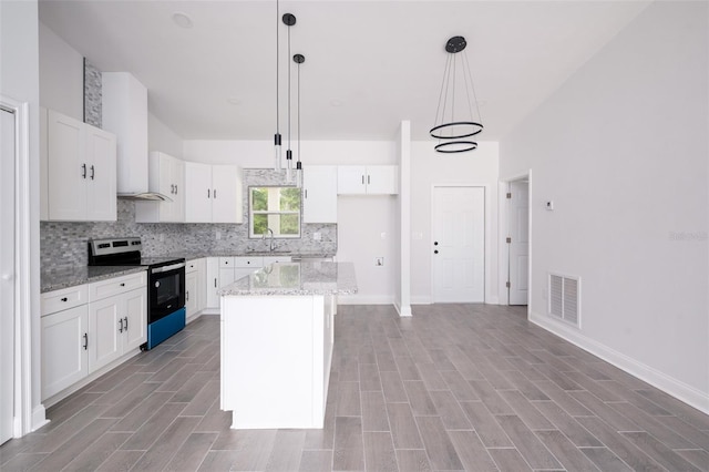 kitchen with pendant lighting, white cabinetry, sink, stainless steel range with electric cooktop, and a center island