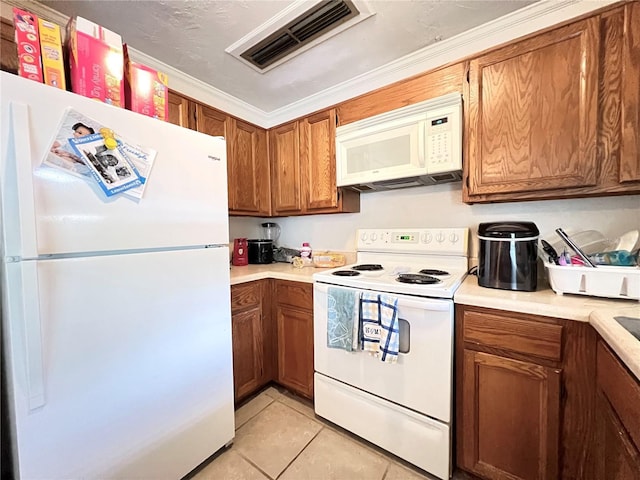 kitchen with light tile patterned floors, white appliances, and ornamental molding