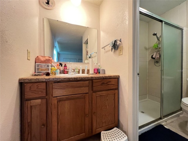 bathroom featuring vanity, toilet, and an enclosed shower