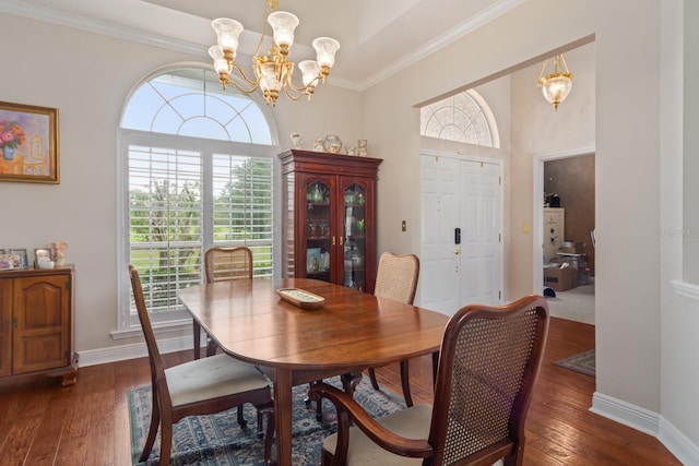 dining area with a notable chandelier, dark hardwood / wood-style floors, and crown molding