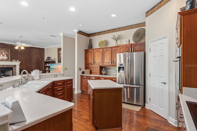 kitchen with stainless steel refrigerator with ice dispenser, a kitchen island, dark wood-type flooring, and sink