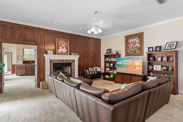 carpeted living room featuring ceiling fan, ornamental molding, and a fireplace