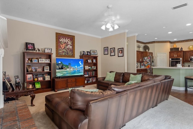 carpeted living room with ceiling fan and ornamental molding