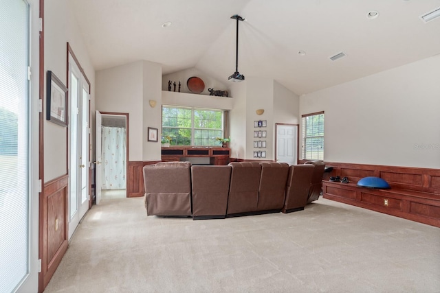 living room featuring high vaulted ceiling and light colored carpet