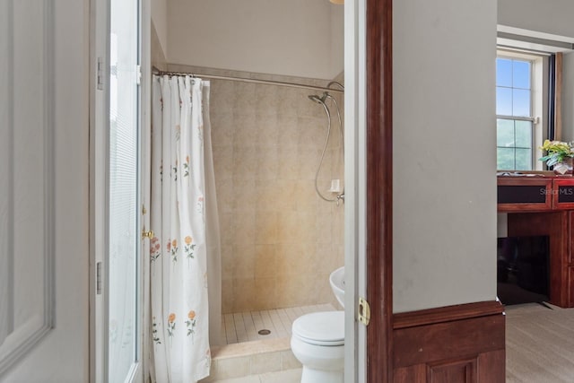 bathroom with a shower with shower curtain and toilet