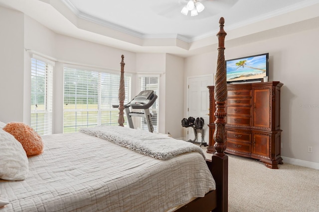 carpeted bedroom featuring a raised ceiling, ceiling fan, and crown molding