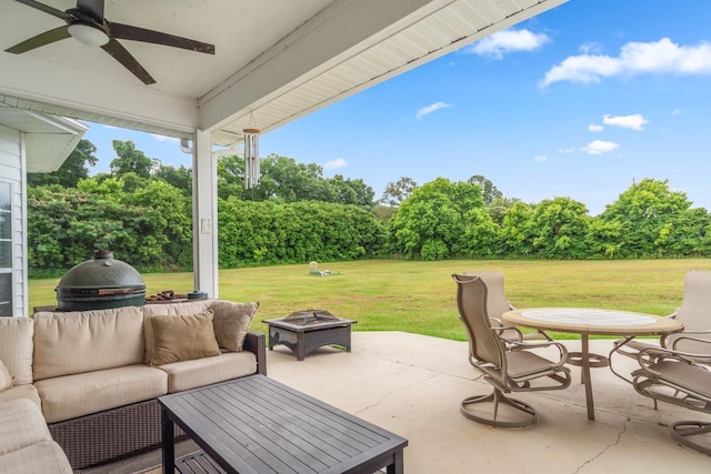 view of patio / terrace featuring ceiling fan and an outdoor living space with a fire pit