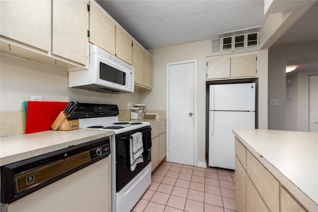 kitchen with light tile patterned floors and white appliances