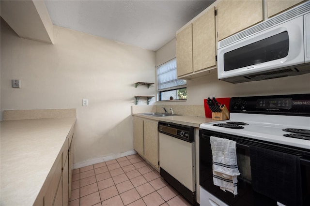 kitchen featuring white appliances, sink, and light tile patterned floors