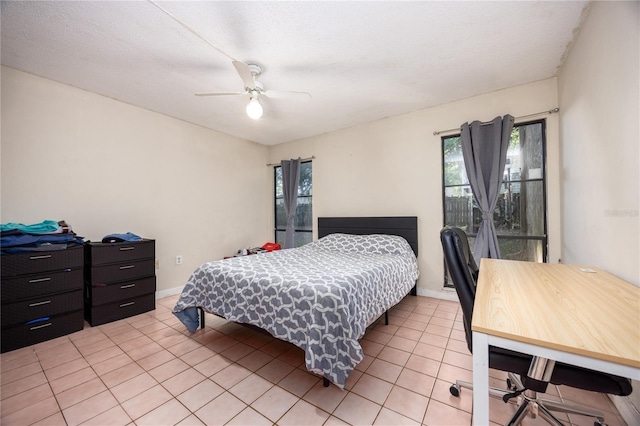 tiled bedroom featuring ceiling fan and a textured ceiling