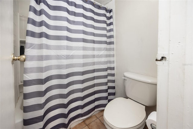 bathroom featuring tile patterned flooring, curtained shower, and toilet