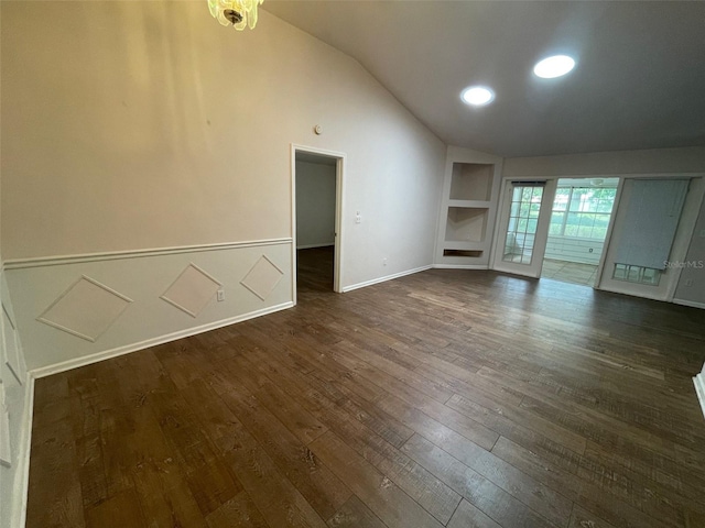 unfurnished living room featuring lofted ceiling, dark hardwood / wood-style floors, and built in features