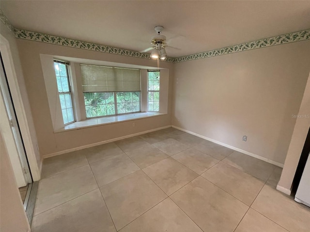 tiled empty room featuring ceiling fan and plenty of natural light