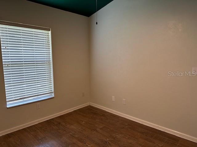 empty room with dark hardwood / wood-style floors